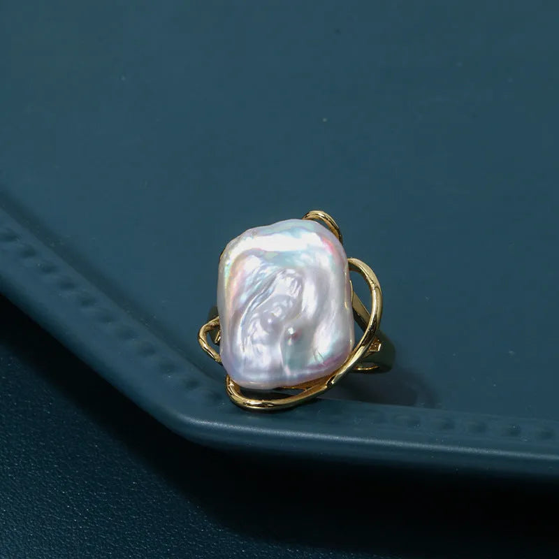 Women's adjustable baroque pearl ring with geometric shape, shown in purple and gold colour options