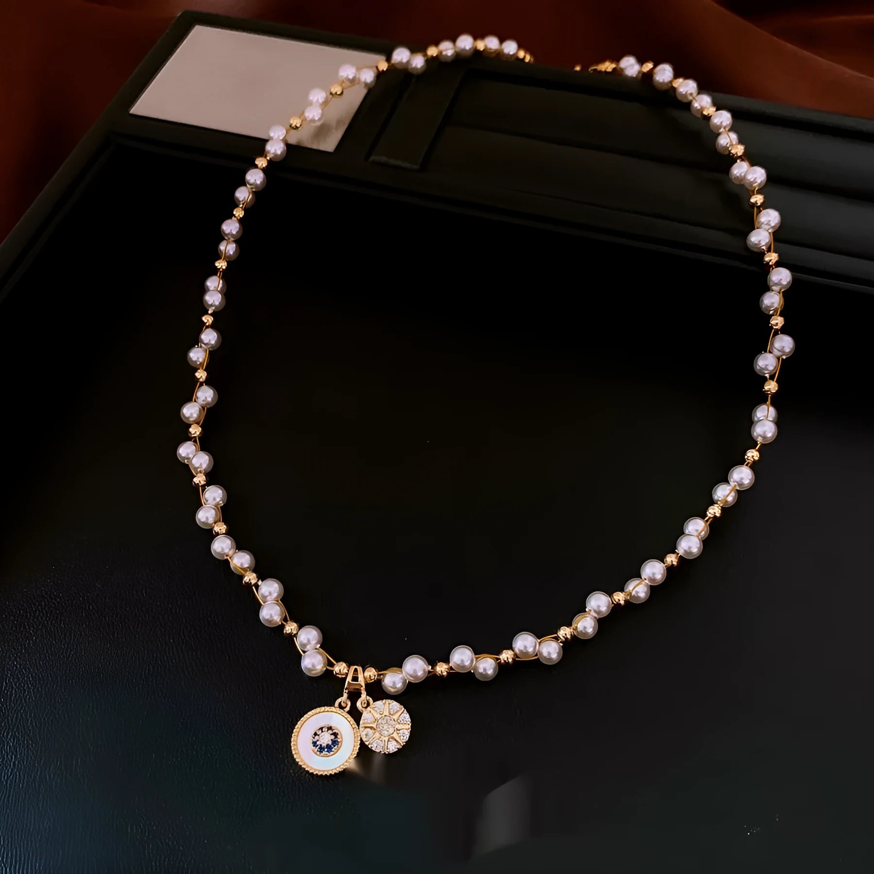 Gold electroplated adjustable clavicle necklace with round zircon and imitation pearl pendant.