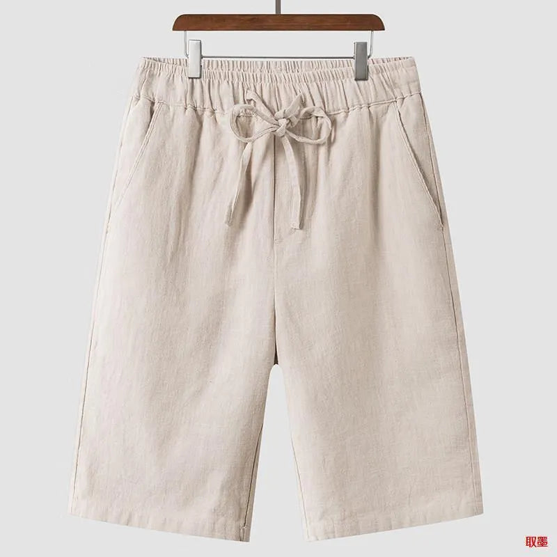 Man wearing beige linen loose-fit cropped shorts on a summer day.