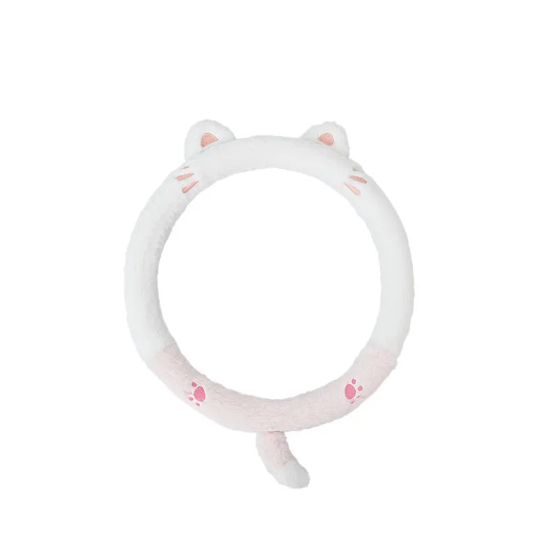 Plush furry steering wheel cover with embroidered panda face, fitted on a car steering wheel.