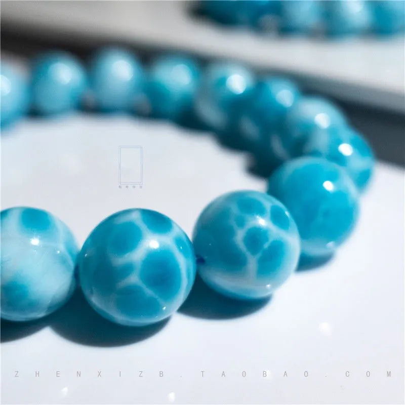 Blue hand-crafted bodhi bracelet with a pearl accent, showing bead sizing options.