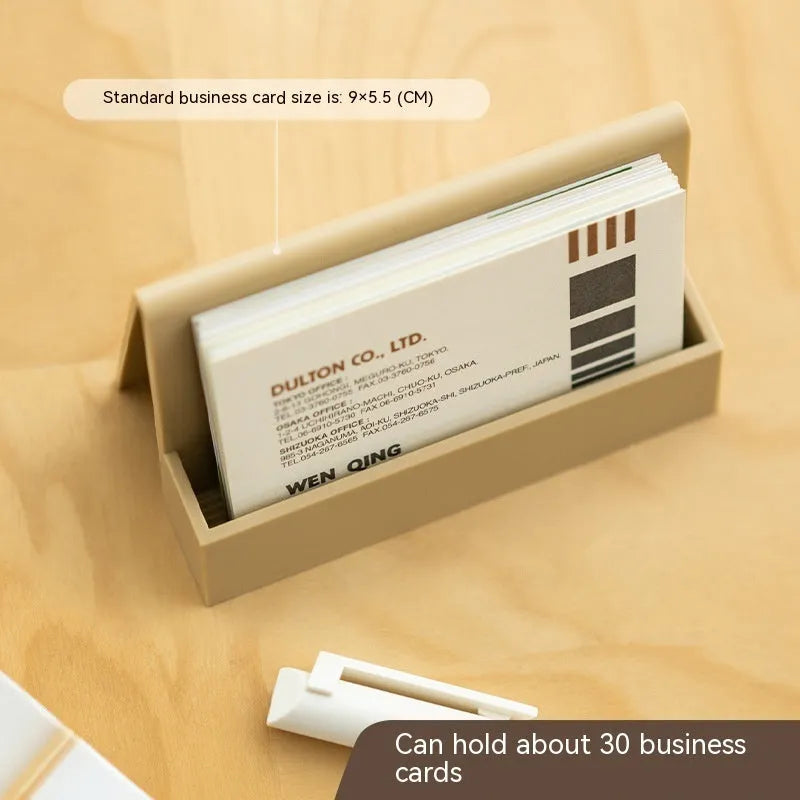 Creative PS geometric business card stand in brown, holding 20 cards upright on a desk.
