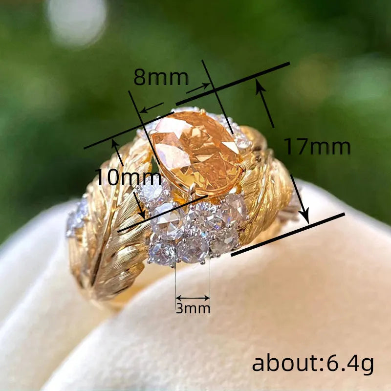 Gold feather embossed women's ring with a yellow zircon stone on a geometric copper band.