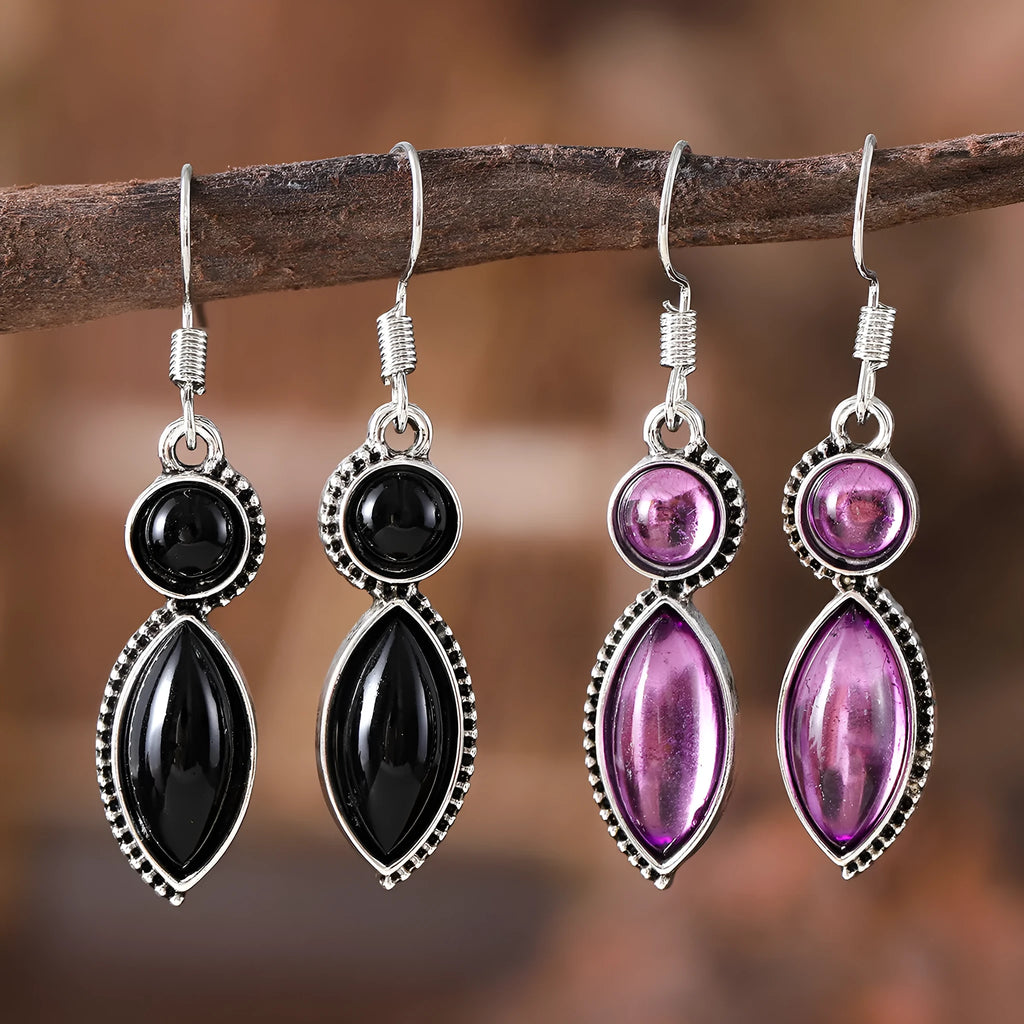 A pair of vintage-style geometric drop earrings with black and purple electroplated pendants on a white background.