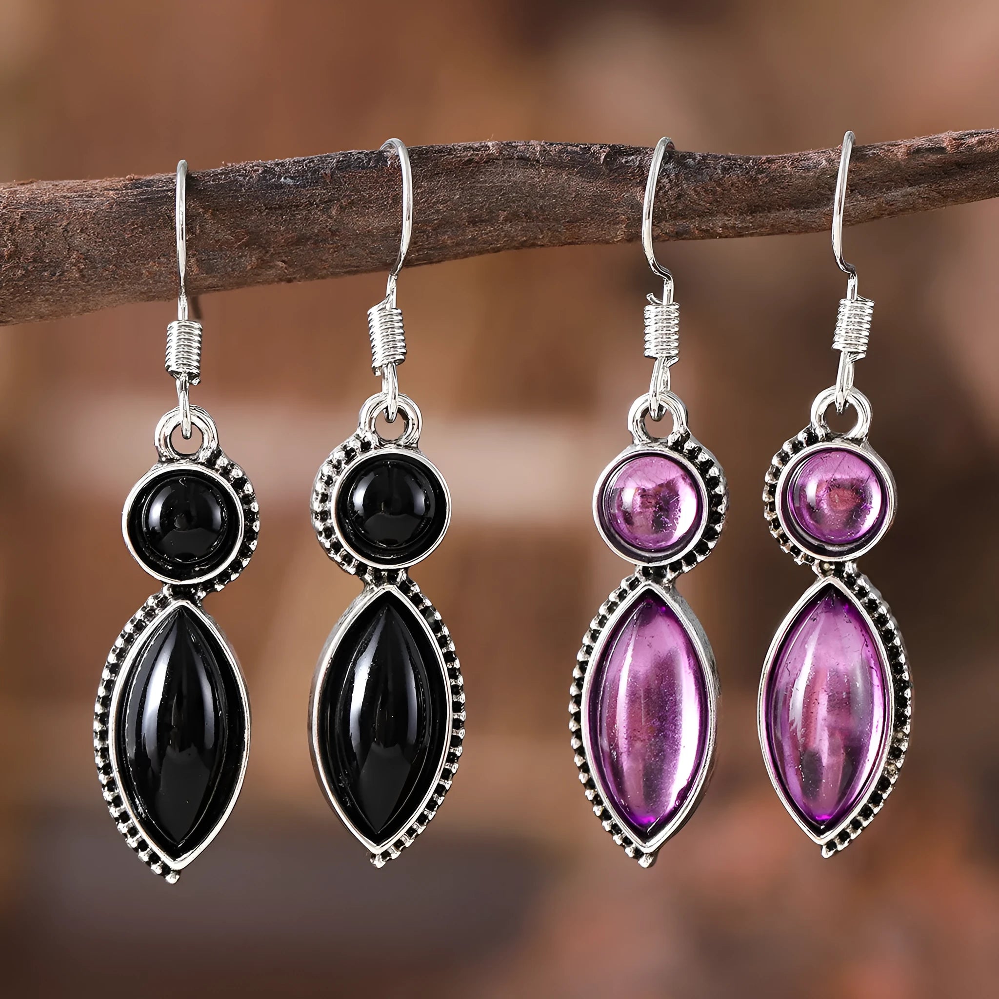 A pair of vintage-style geometric drop earrings with black and purple electroplated pendants on a white background.