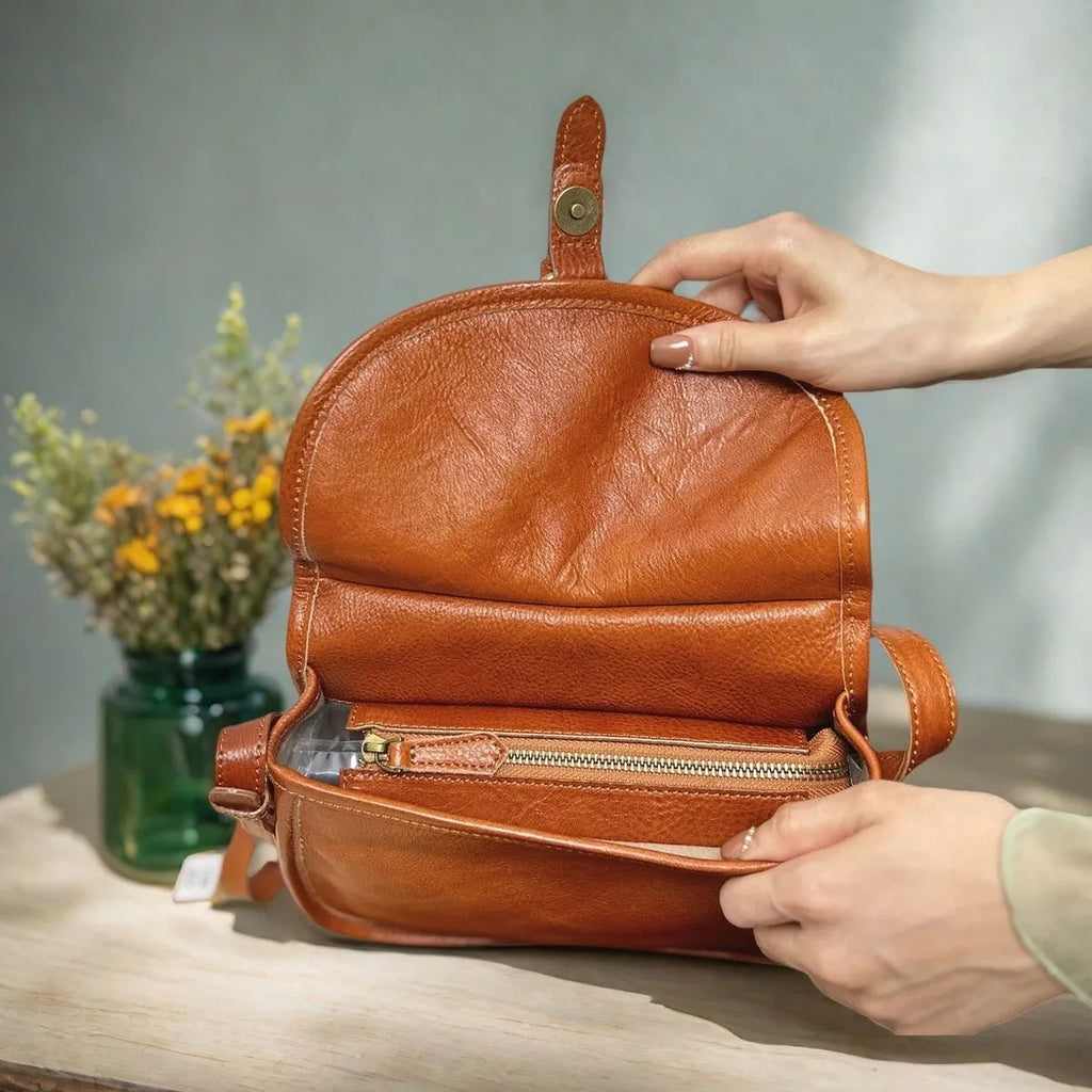 Brown genuine leather messenger bag with flap closure and crossbody strap showing internal organiser compartments