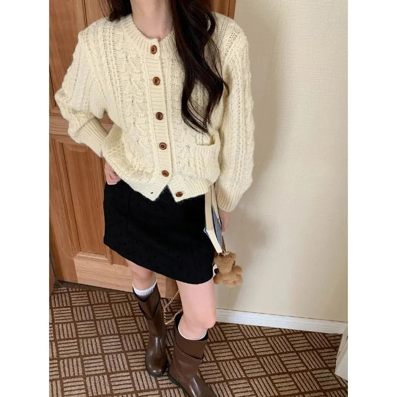 Solid colour thick needle twisted texture knitted cardigan in beige, short length, on model