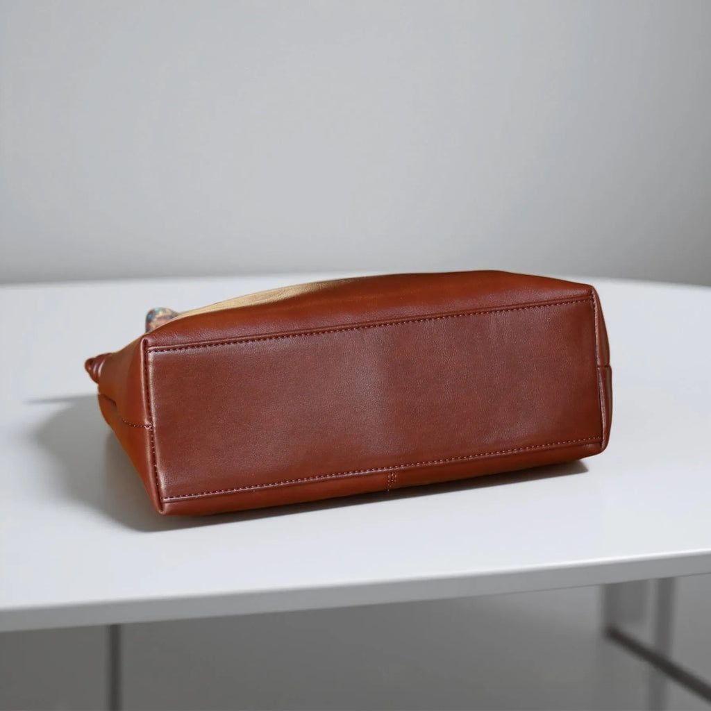 Genuine leather pillow-shaped commuter bag in caramel colour with double straps and patchwork detailing, 31x11x24cm