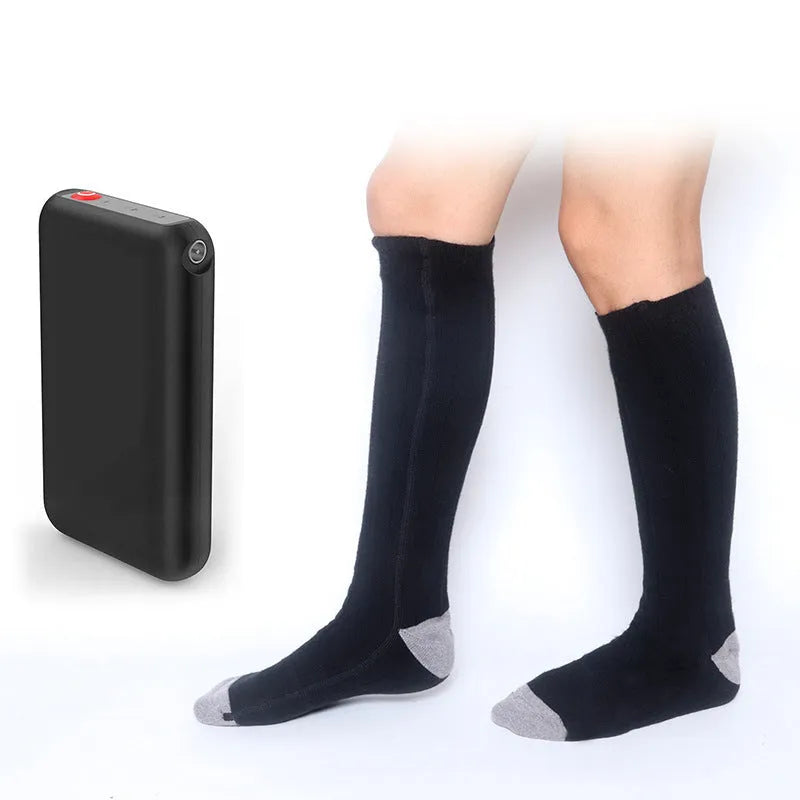 Electrically heated socks in black textile fabric with rechargeable ABS battery pack visible in pocket