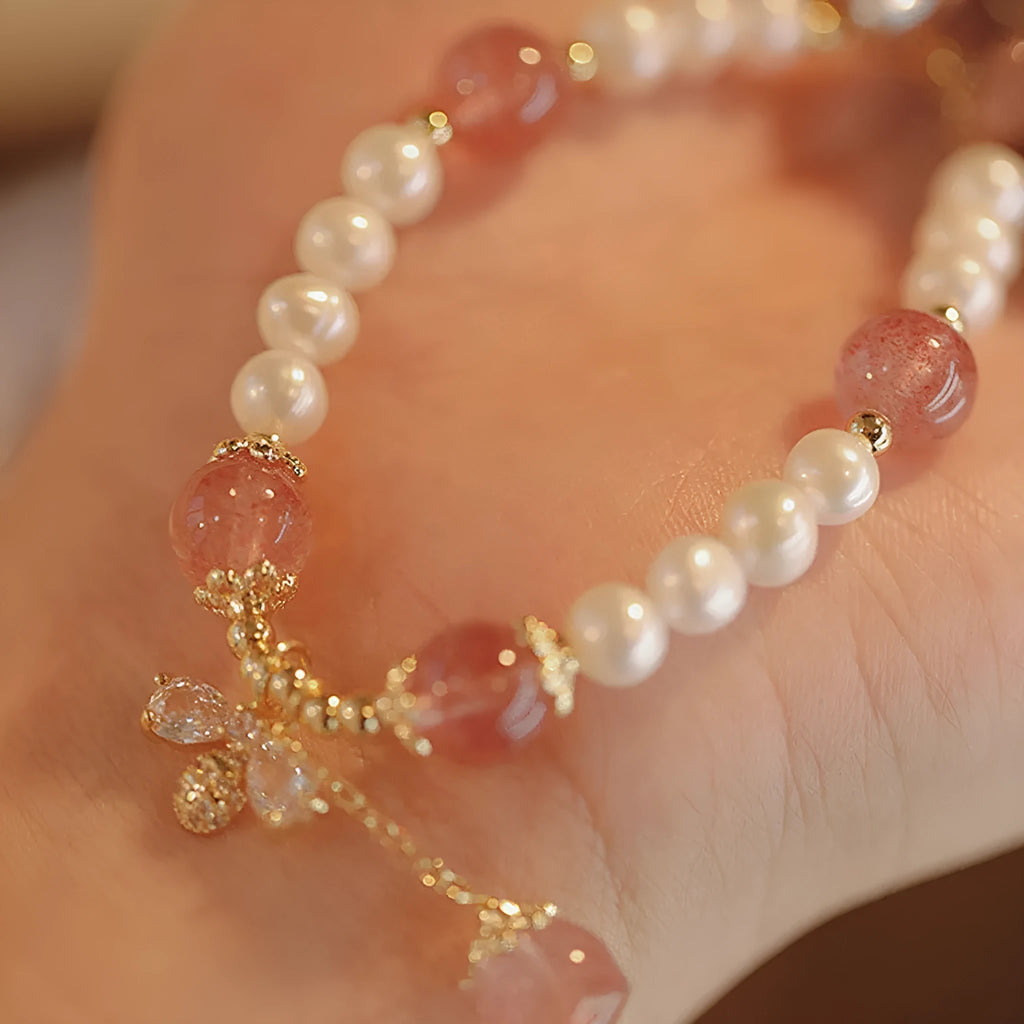 Handmade women's strawberry quartz crystal bracelet with a decorative bow clasp.