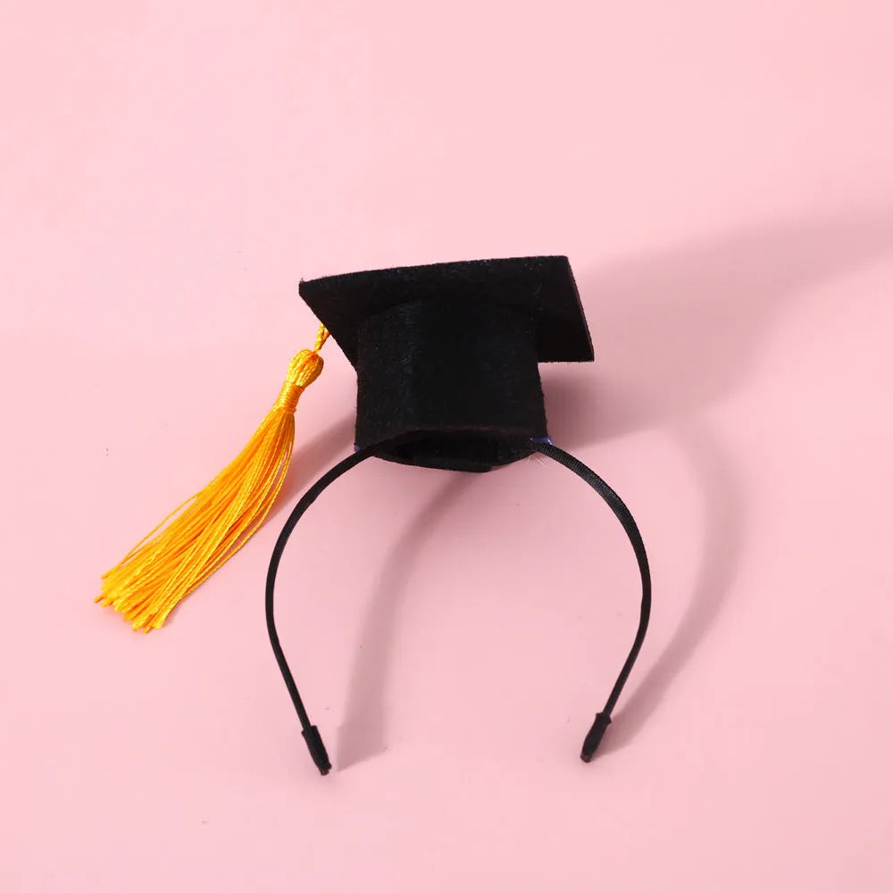 Pet wearing a British-style graduation cap hair band and matching bow tie