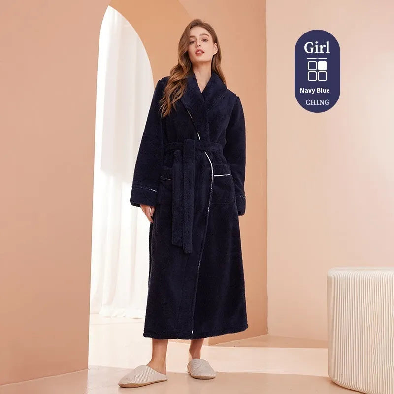 A man and woman wearing matching navy blue thick flannel bathrobes, showcasing the wrap-around design and plush fabric.