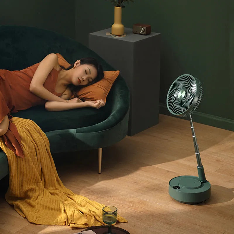 Green telescopic floor fan extended to full height with magnetic remote control attached