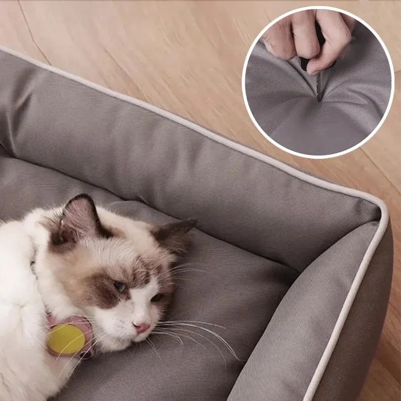 Grey waterproof dog sofa bed with raised edges on wooden floor