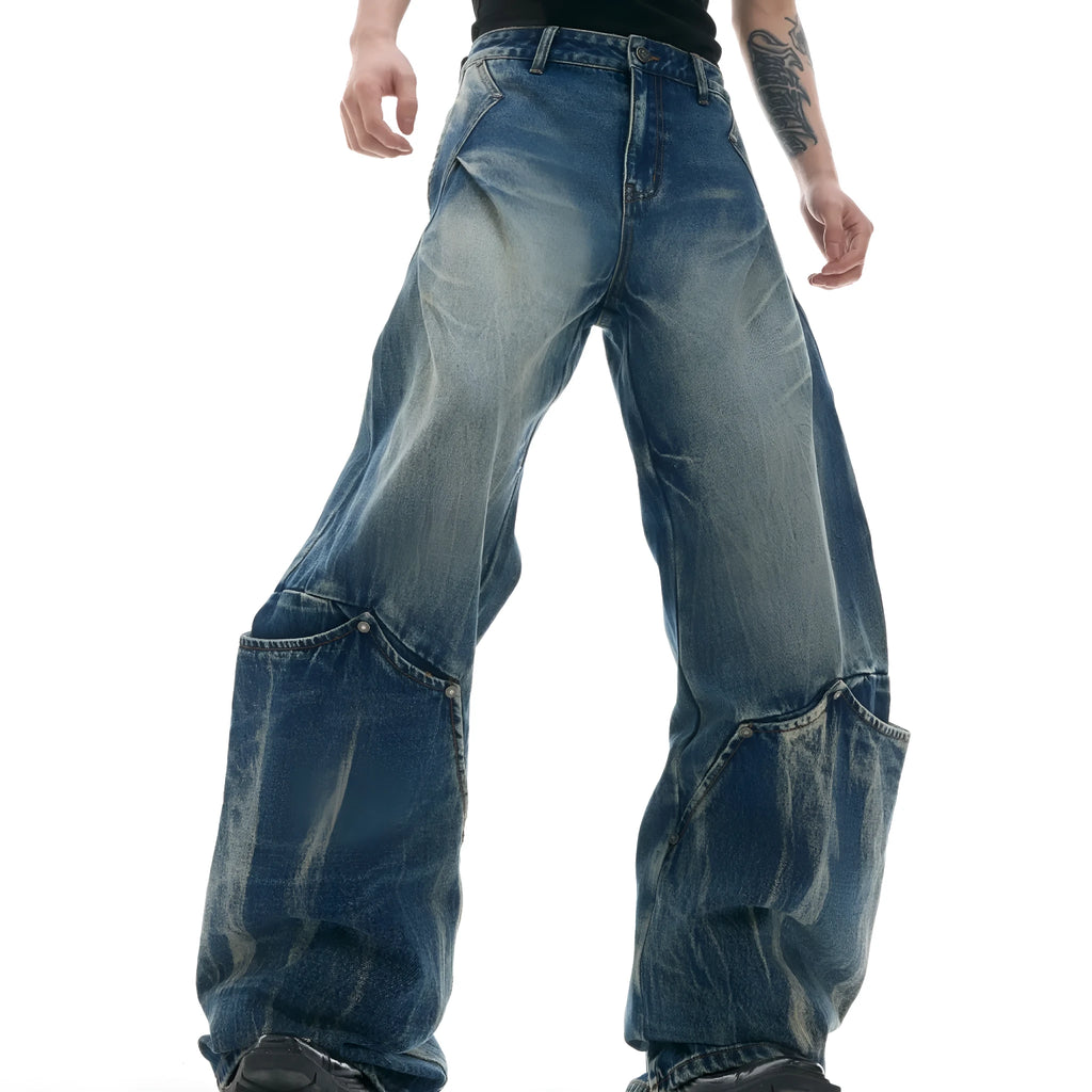 Man wearing Verdant Blue loose fit jeans with a retro washed burst pattern and a curved knife leg silhouette.