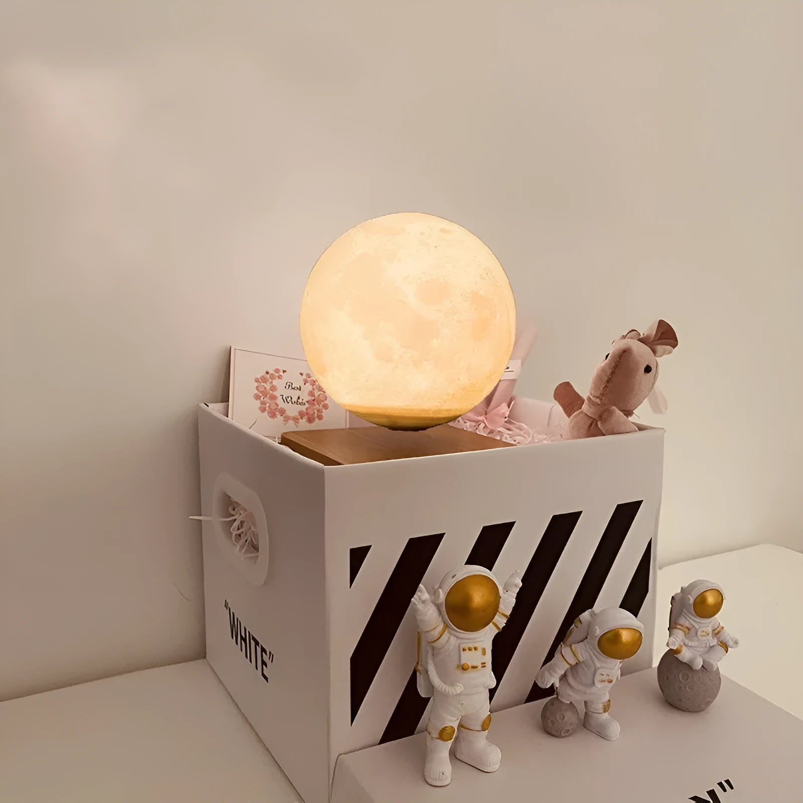 Maglev moon and planet night light floating above base with three astronaut figurines