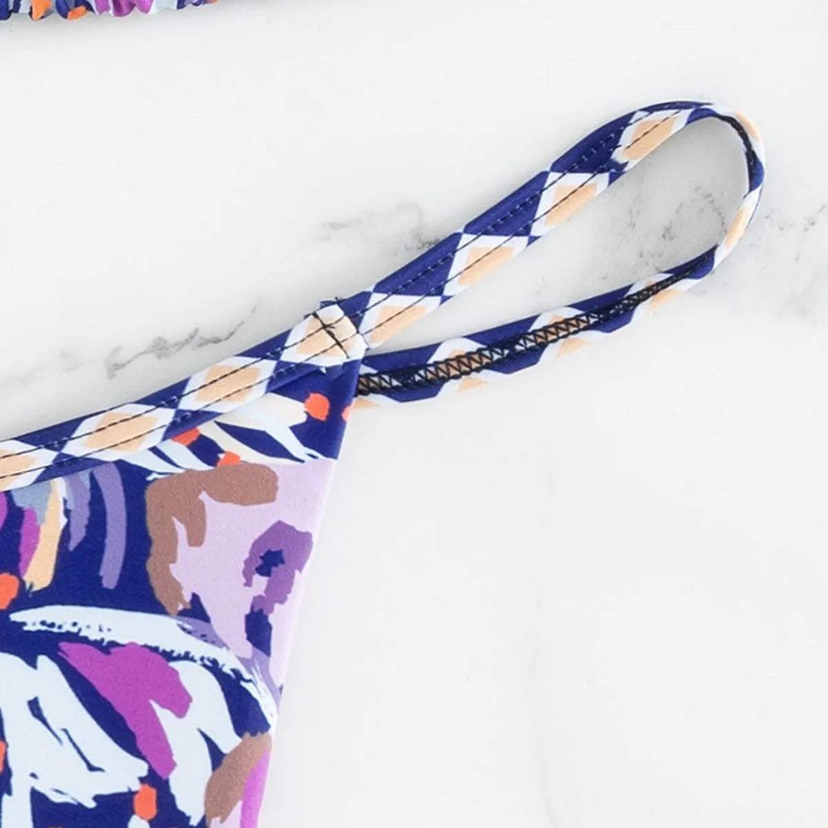 Women's floral print triangle bikini swimsuit with adjustable tie sides on white background