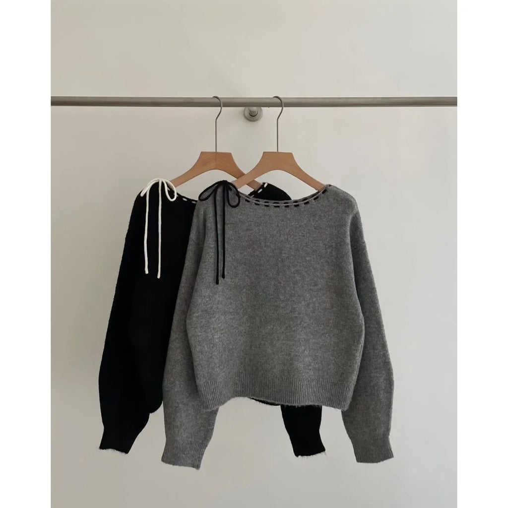 Grey loose-fitting women's pullover knitwear top on a hanger.