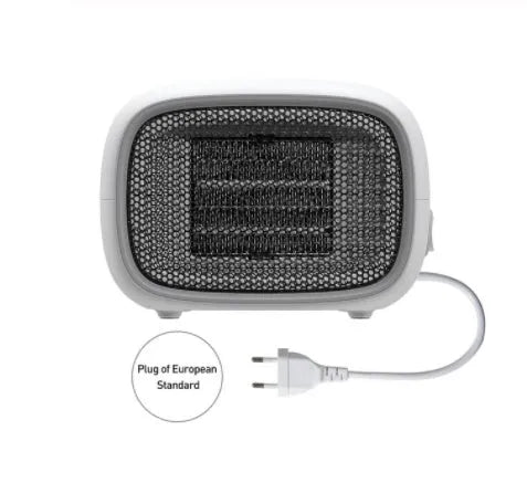 Compact green mini ceramic desk heater with metal mesh front grille, shown next to a pen for scale.