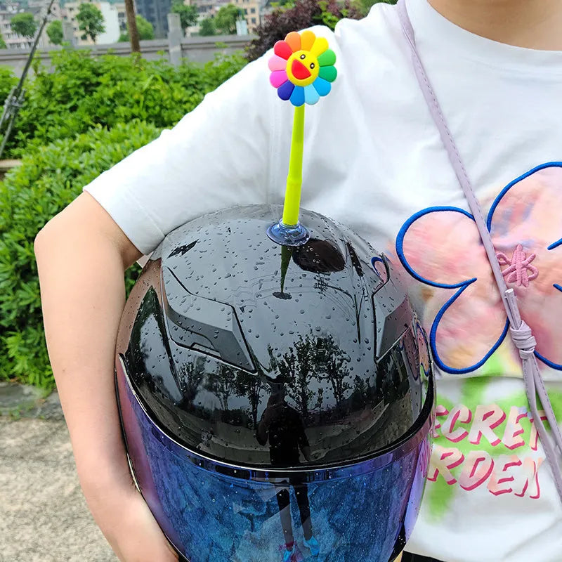Yellow silicone sunflower helmet decoration with a black suction cup base attached to a helmet.