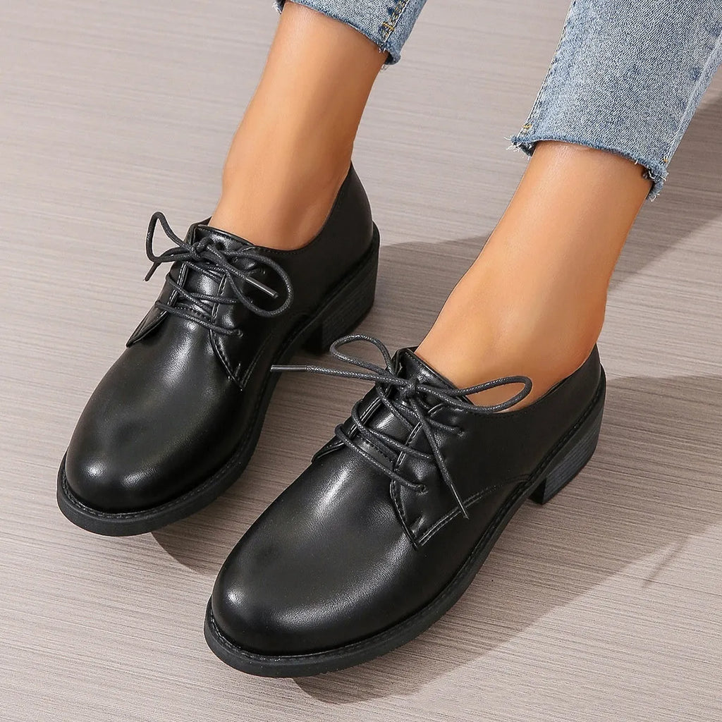 Black women's low-top work shoes with a chunky mid heel and rubber sole.