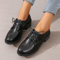 Black women's low-top work shoes with a chunky mid heel and rubber sole.