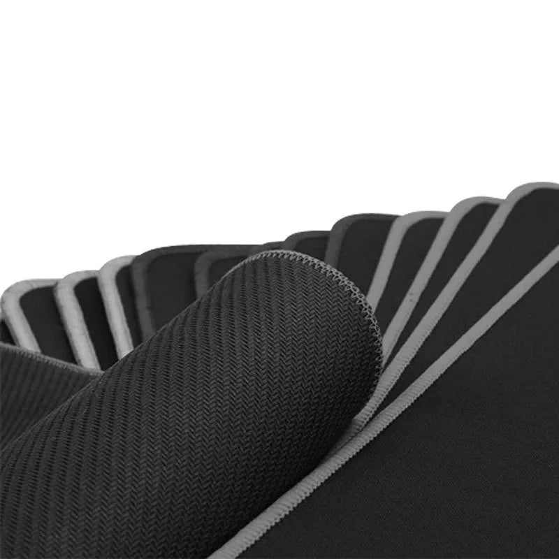 Extra long black cloth mouse pad with overlock edge on a desk