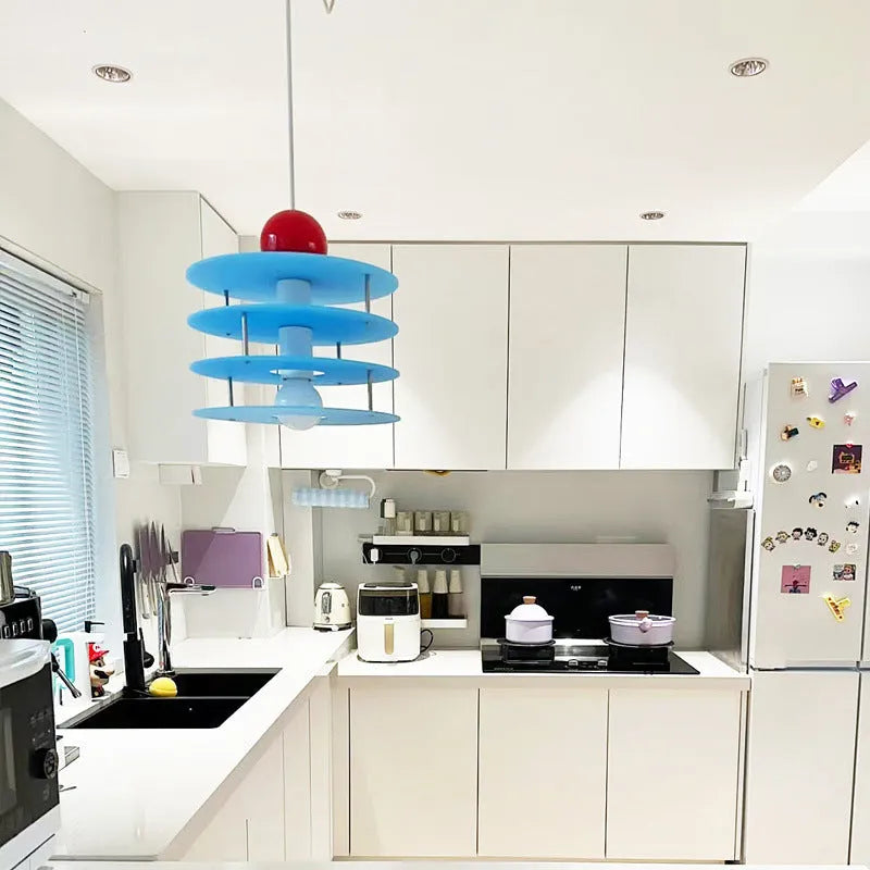 Macaron-shaped adjustable chandelier light fixture with a frosted shade, shown in a dining setting.