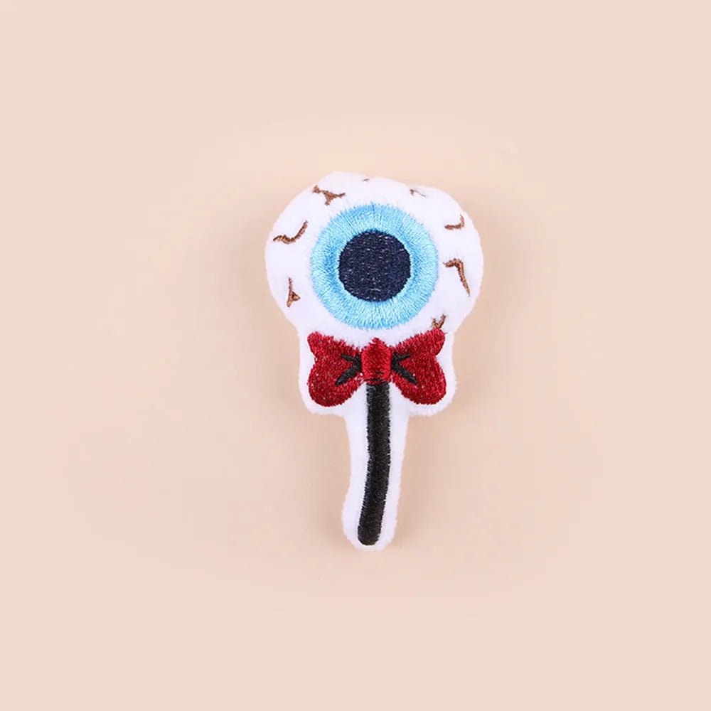 Small colourful plush cat teaser wand with candy, eyes, and skull designs