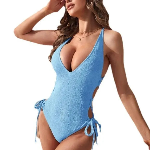 Women's solid-colour backless one-piece swimsuit with a tether strap detail on the back.