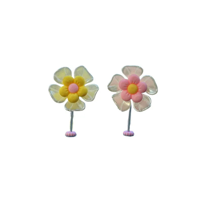 Small colourful plastic swing ornament for car dashboard, shown in blue, green, pink, purple, and yellow.