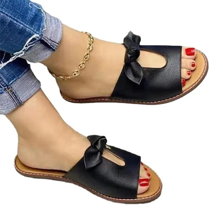 Women's black fishmouth sandals with a decorative bow on the strap, showing the open toe and rubber sole.