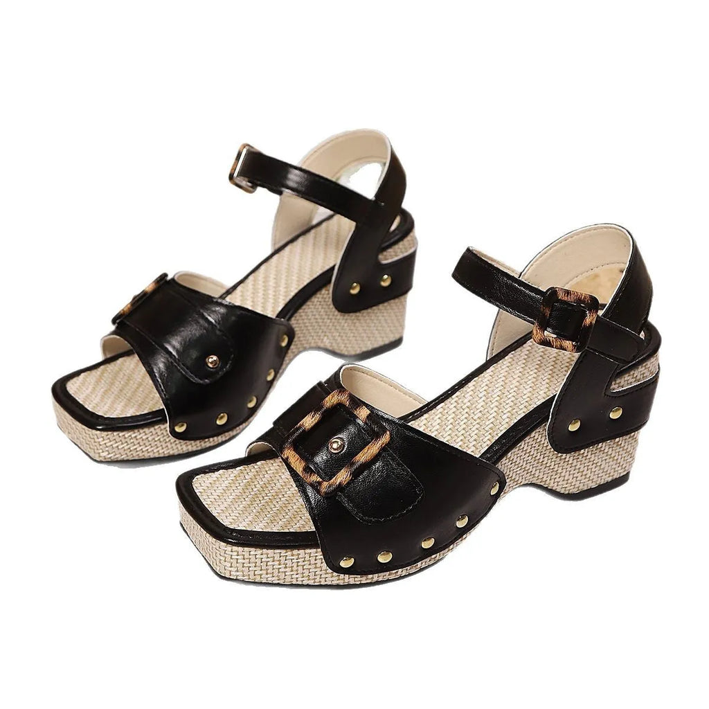 Women's white buckle-strap sandals with a chunky heel and metal clasp on a plain background.