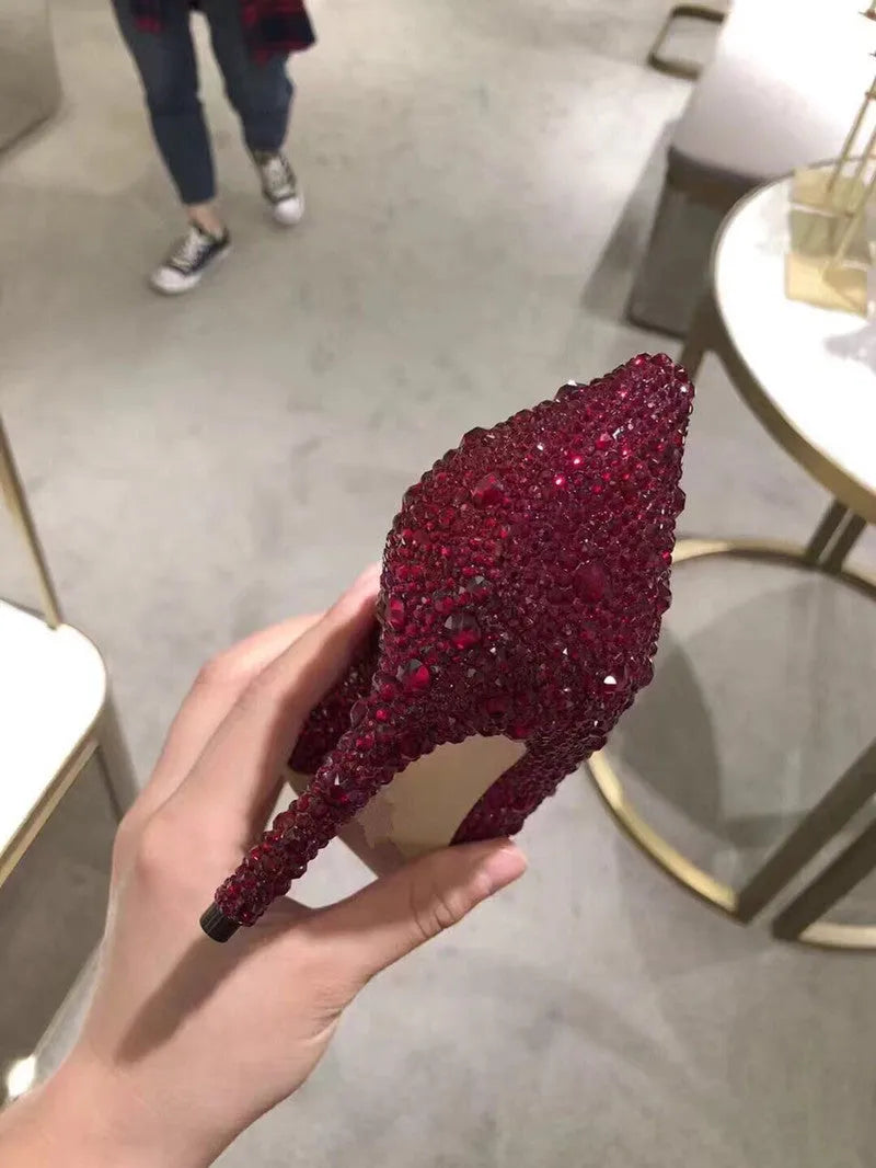 Gold women's stiletto heels with sequin upper, rhinestones, a bow, and a pointed toe.