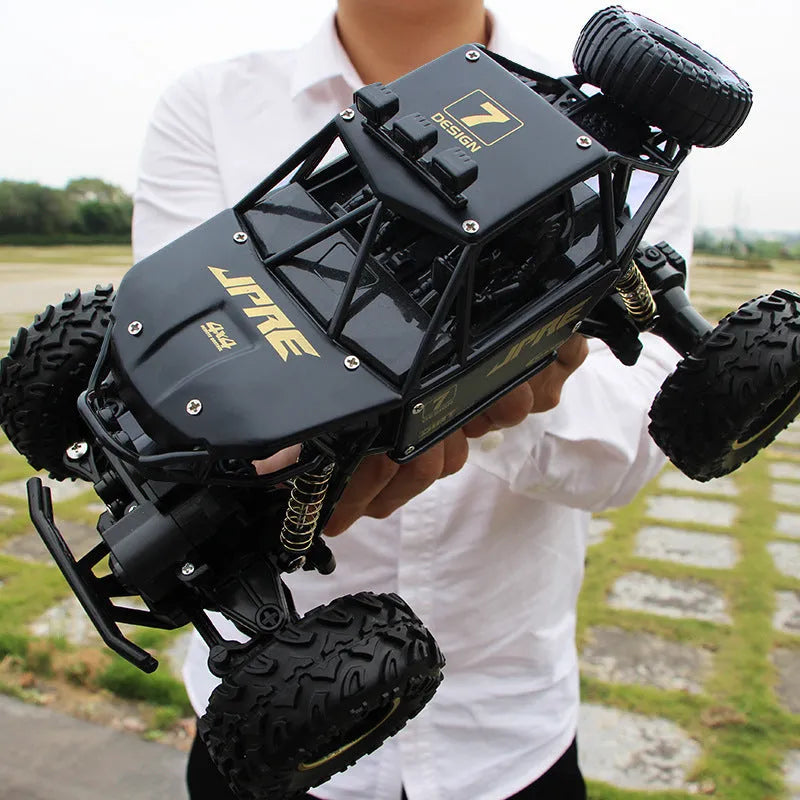 Large black 4WD off-road remote control car with 2.4G wireless controller on rough terrain