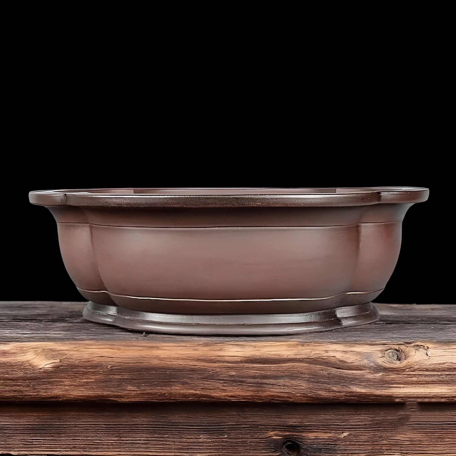 Handmade antique crabapple shaped purple clay flowerpot on a wooden floor.