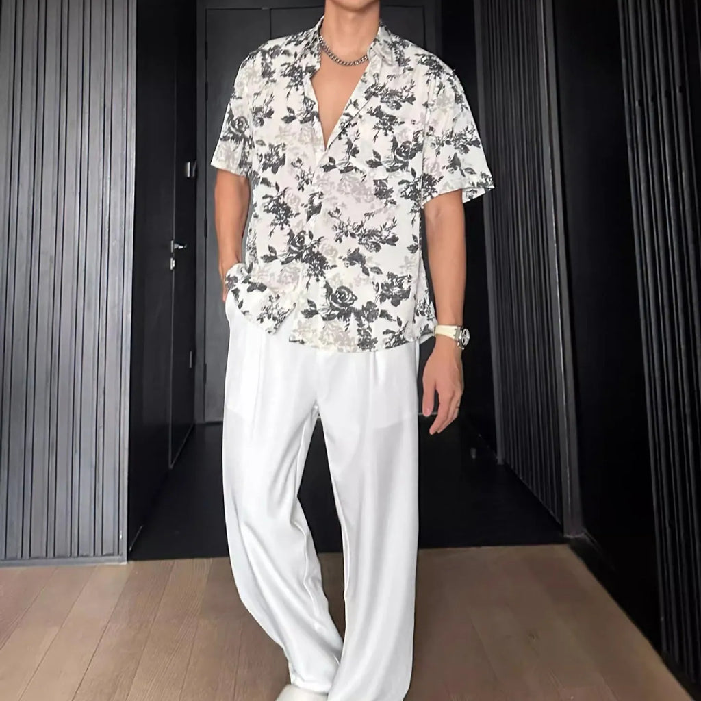Loose-fitting black floral print short sleeve shirt on a hanger.