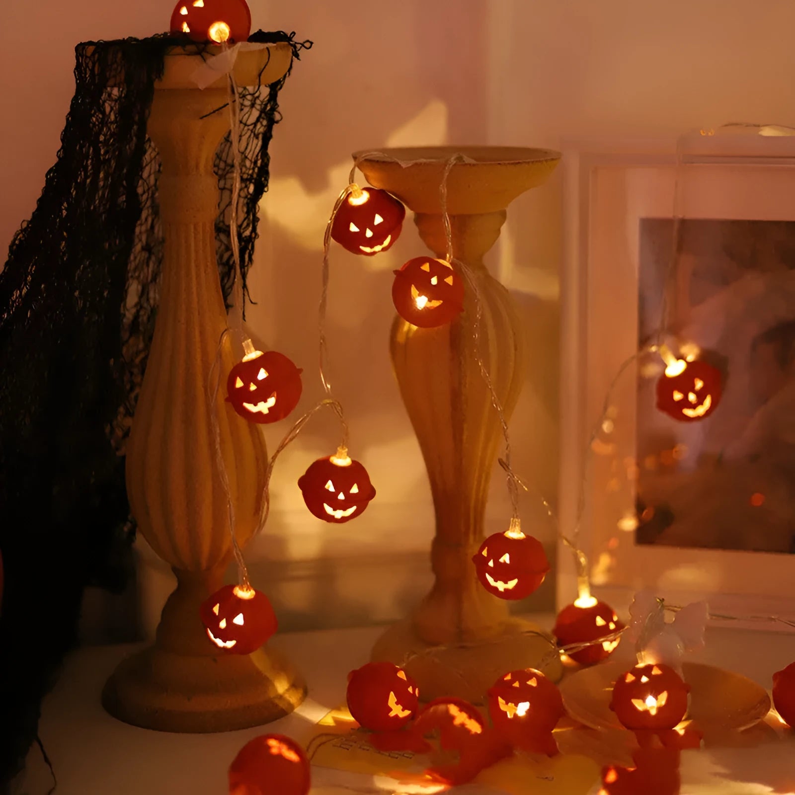 Halloween pumpkin string lights with warm white LEDs and iron pendants on a dark background