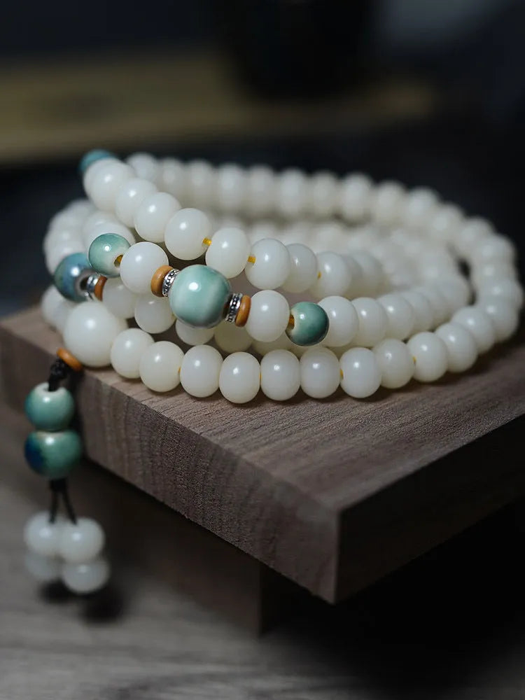 White jade bodhi root oblate bead bracelet with 108 flat round beads in 7x9mm and 8x10mm sizes.