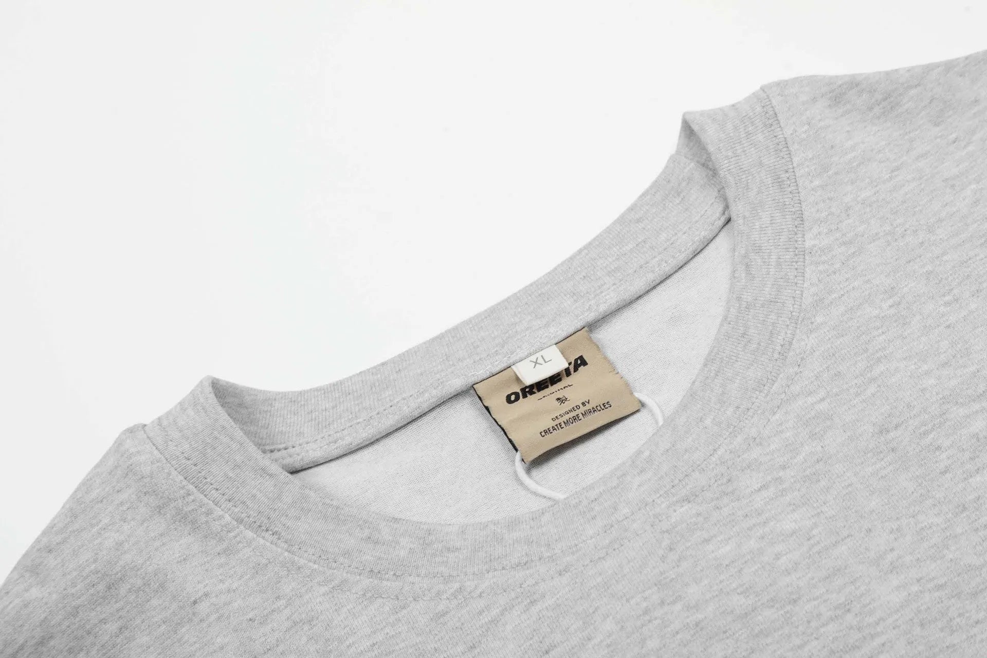A man or woman wearing a loose grey cotton long sleeve retro pullover.