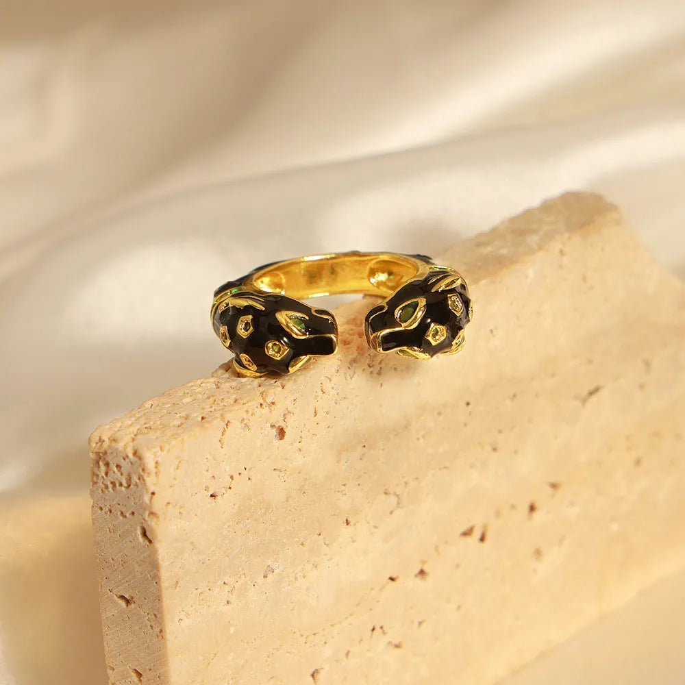 Geometric open fashion ring with a black cheetah print pattern, shown on a model's hand.