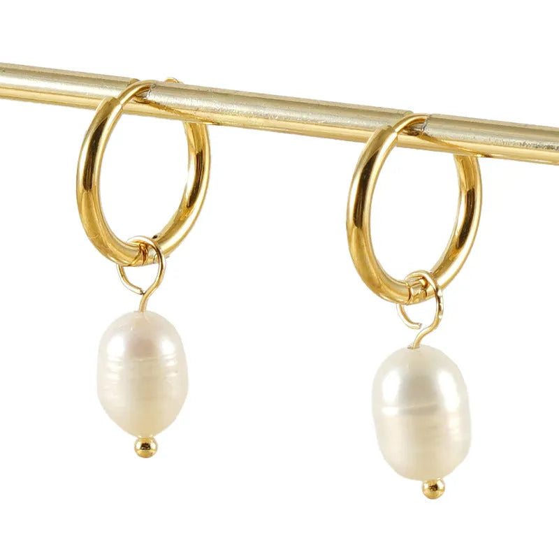 Gold geometric drop earrings with a central freshwater pearl on hypoallergenic posts.