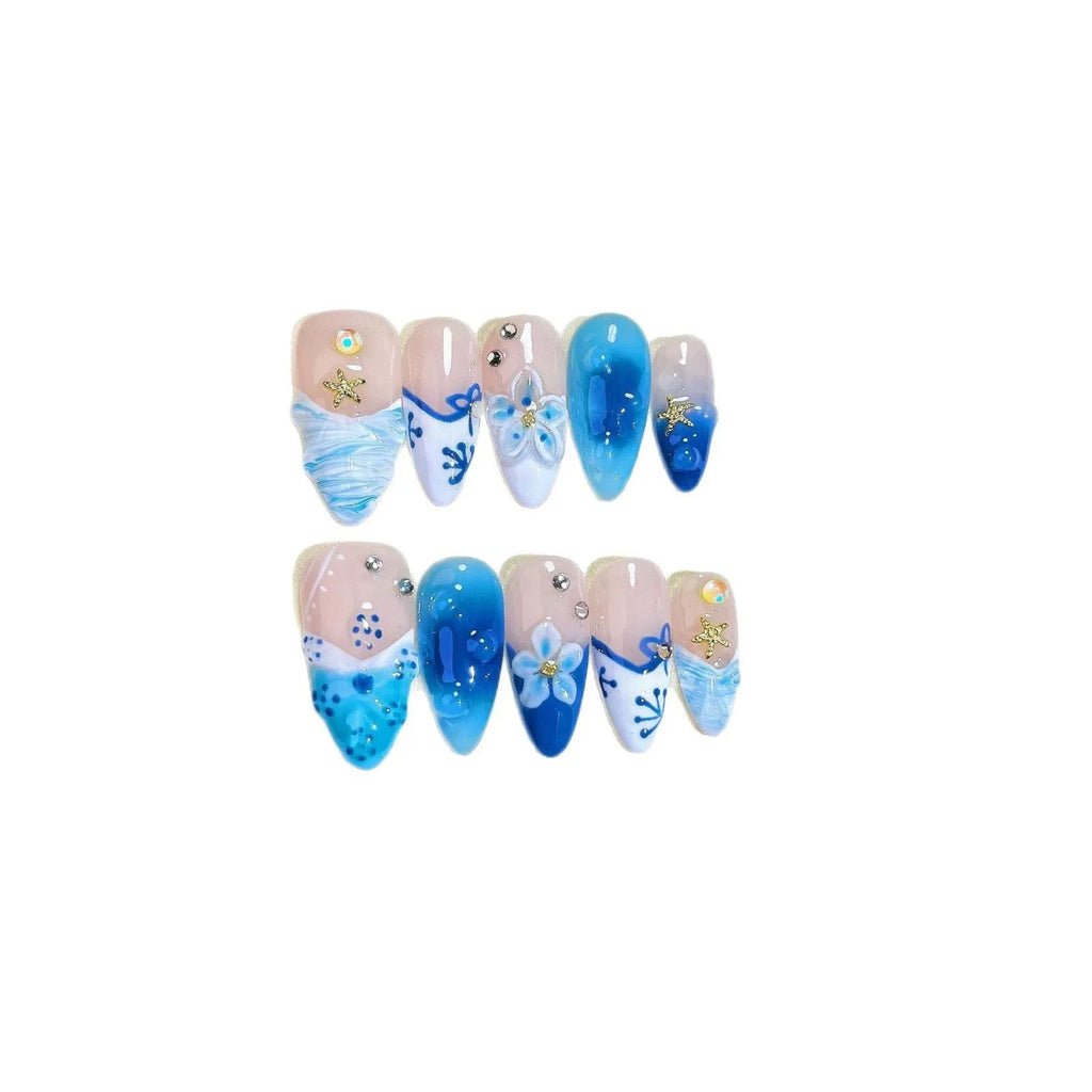 Blue hand-painted carved plastic fake nails on a clear background.
