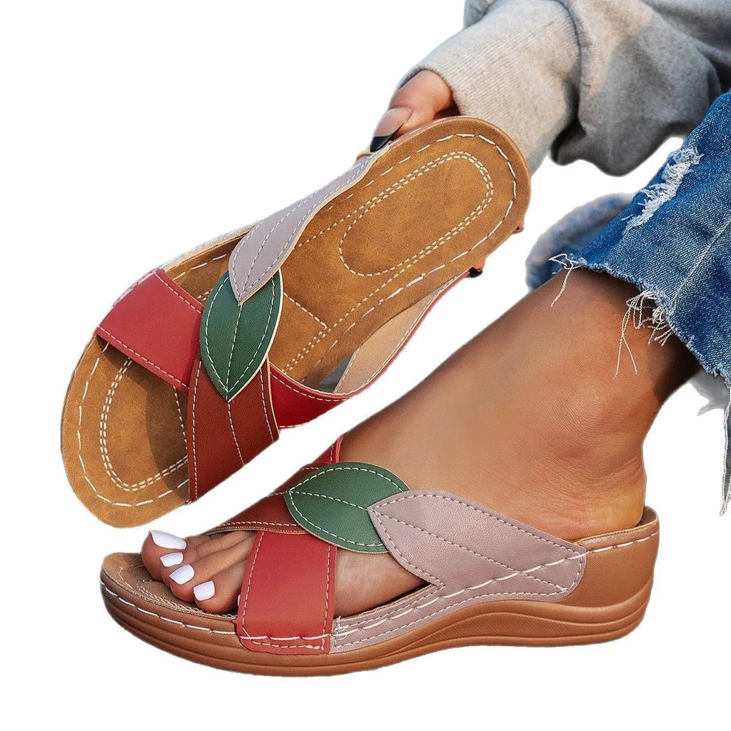 Women's black thick-soled slippers with a cross-strap and peep-toe design on a light background