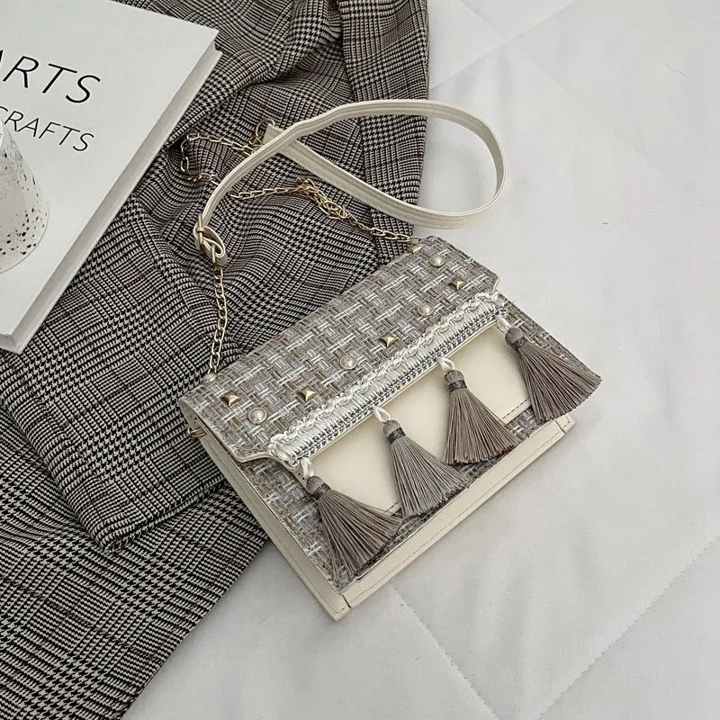 Ethnic-style horizontal square PU bag in beige with polyester lining, medium-hard structure, and flat lay on surface