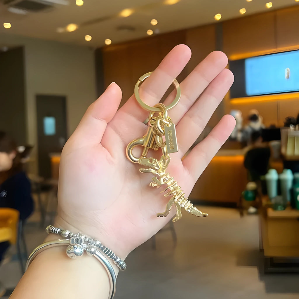 Zinc alloy dinosaur keychain with golden bone dragon pattern on grey background