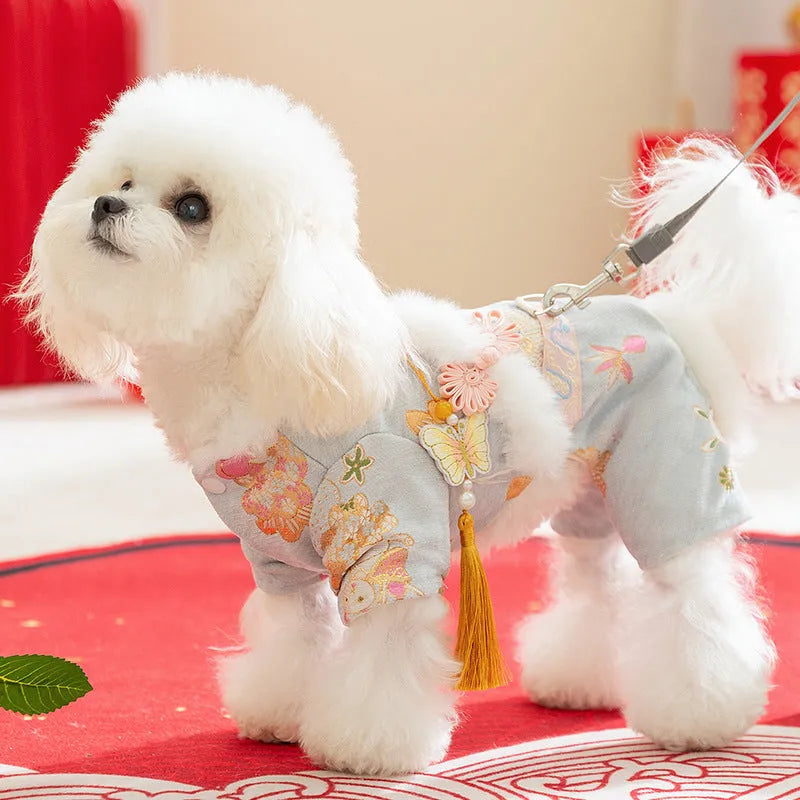 Light blue cheongsam pet coat with embroidered floral motifs, butterfly ornament, golden tassel, faux fur trim, and metal leash ring