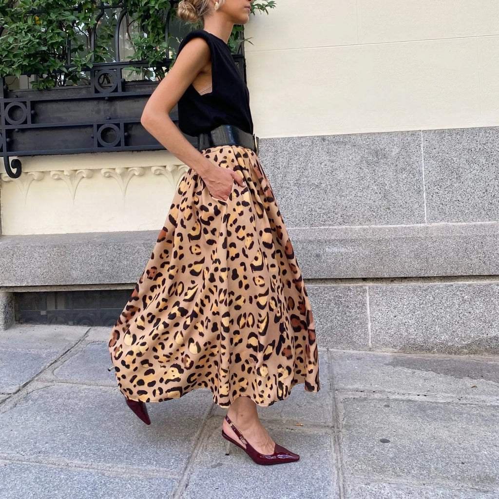 Brown leopard print women's long A-line skirt with a wide, flowing hem on a hanger.