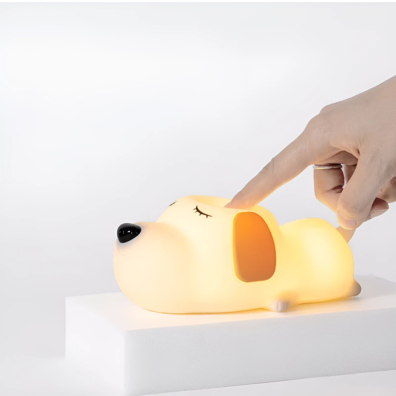 Cute silicone dog night lamp with two-color USB charging light on a wooden table