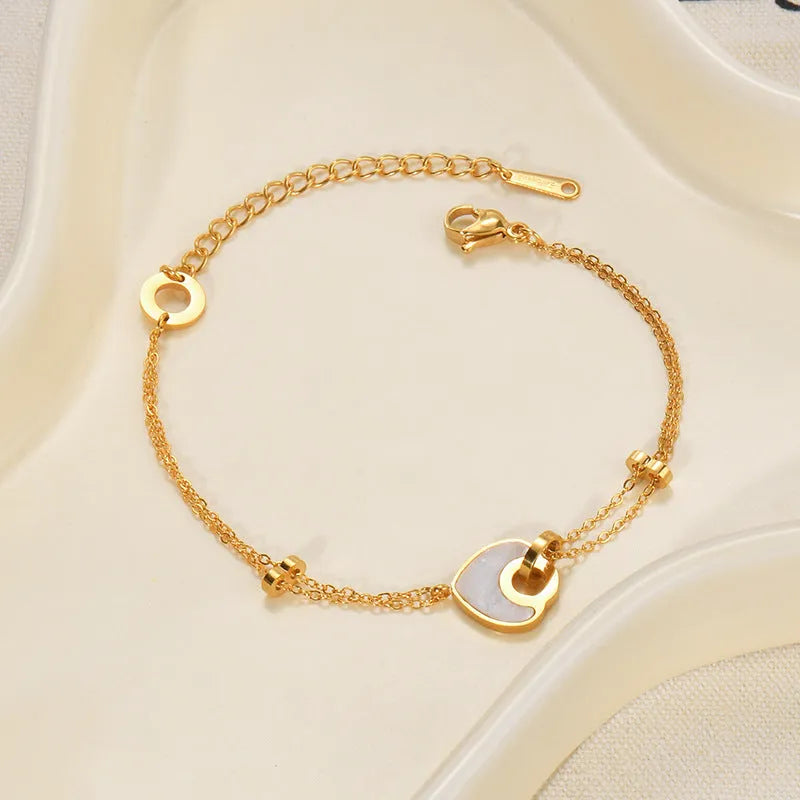 Women's adjustable stainless steel bracelet with a double-layered resin heart charm.